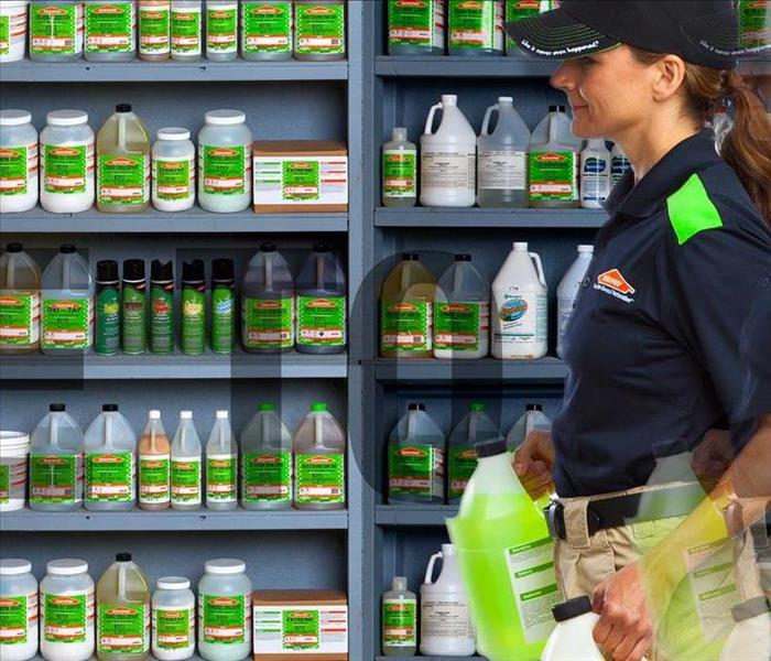 SERVPRO employee carrying cleaning chemicals